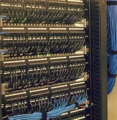 Network Rack that was cleaned up by charlotte data solutions using blue cat 6 cables.