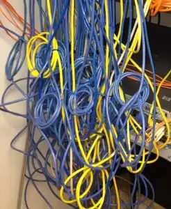 Network Rack that has a pile of network cabling all a mess to the point you can not see the network switch. Charlotte Data solutions will soon come in and fix this mess and resture this rack to a neat and clean setup